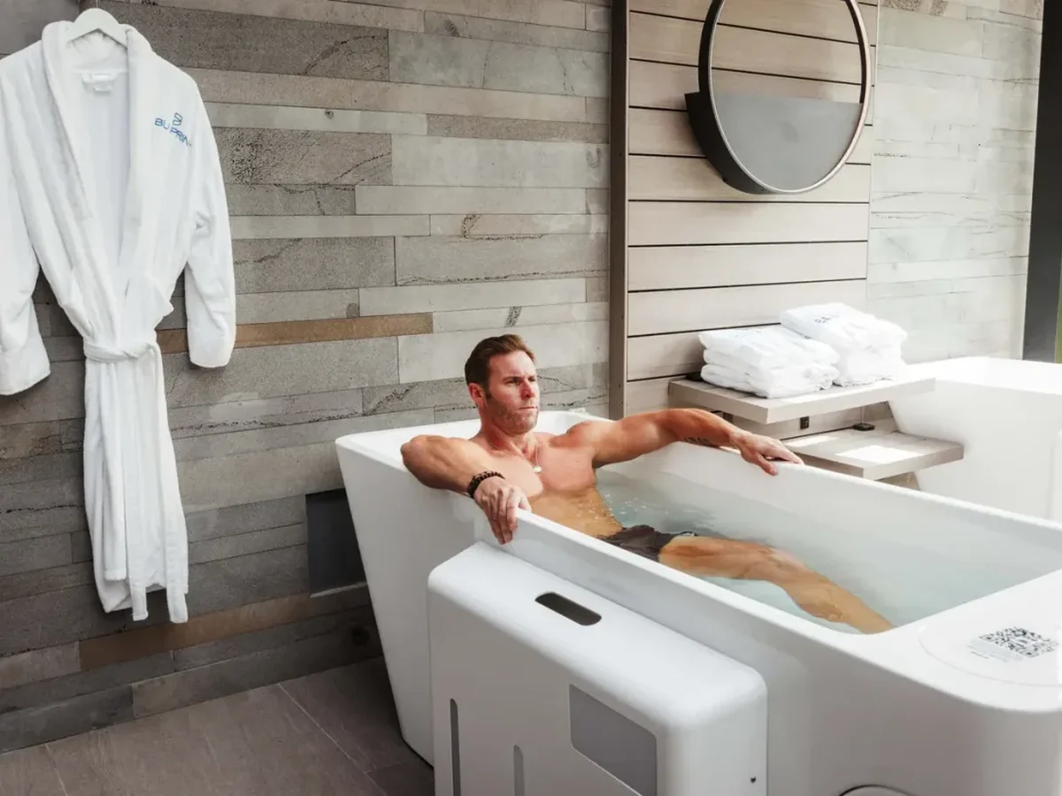 Member in a robe beside the cold plunge at Bluprint Wellness