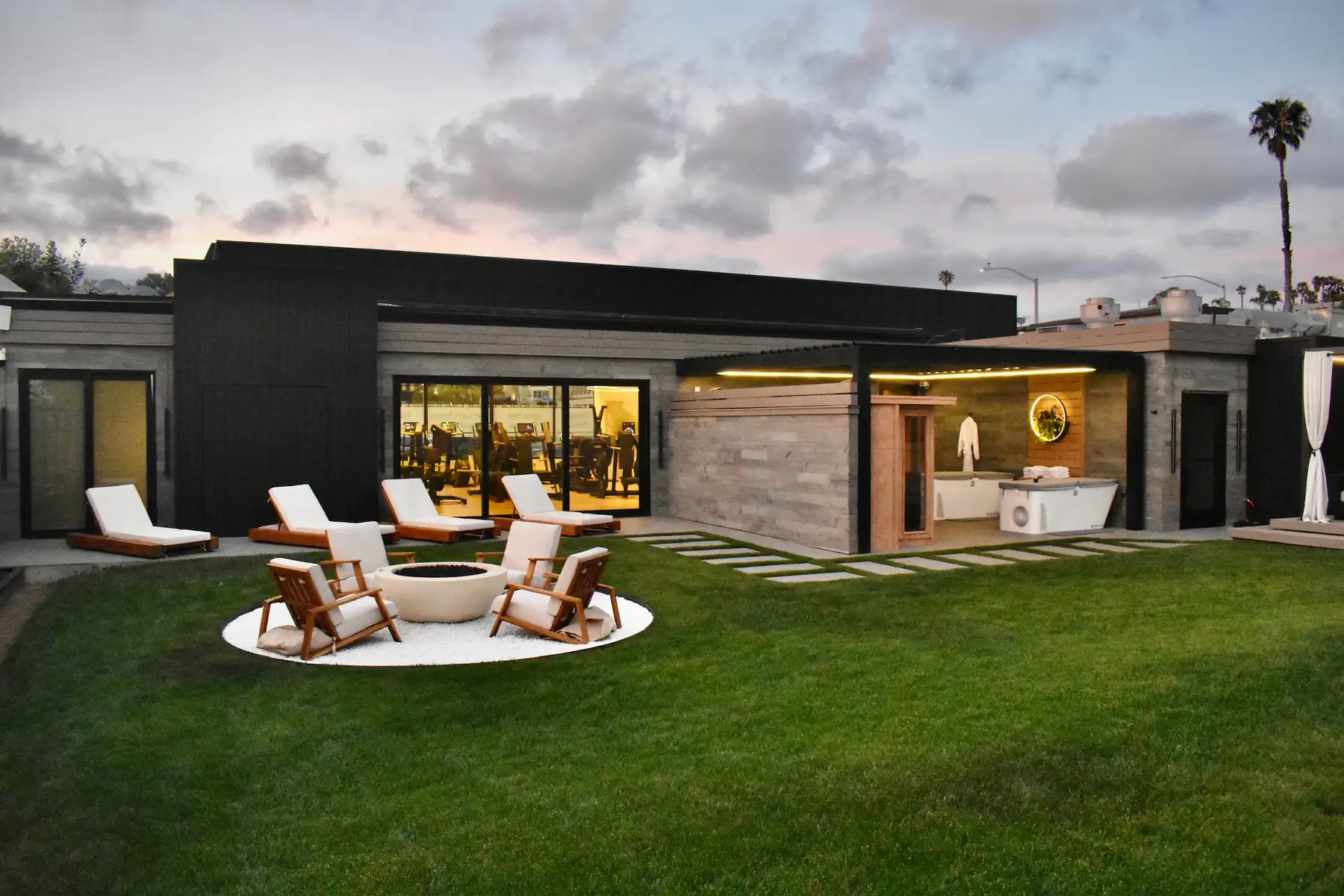 The Bluprint Wellness outdoor lawn, fire pit, and studio exterior at dusk in Solana Beach